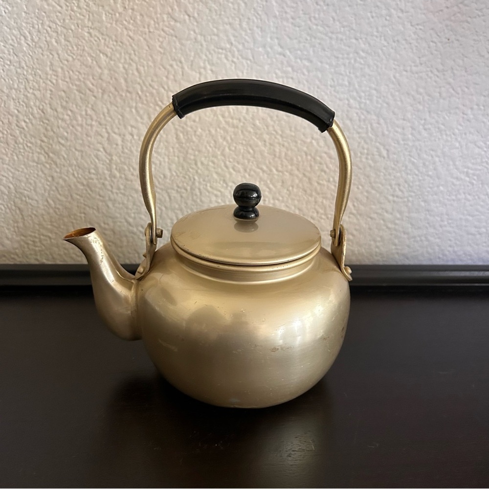 vintage gold-toned aluminum teapot with a black handle mid century modern 5” dia